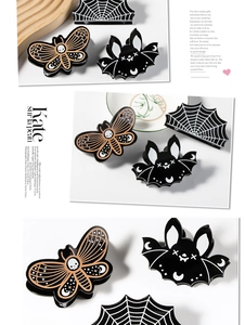 Detailed view of Halloween hair clips featuring spider web, bat, and skull moth designs