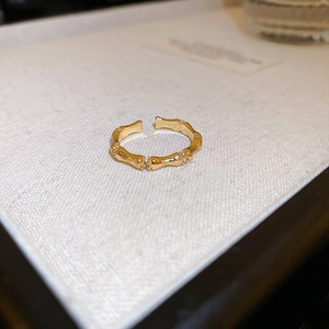 Detailed close-up of golden bamboo joint ring with shimmering white zircon stones