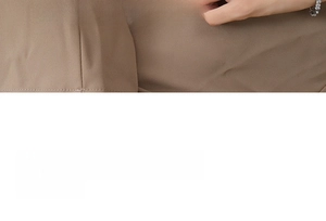 Detail of silver chain bracelet paired with professional brown blazer for minimalist style