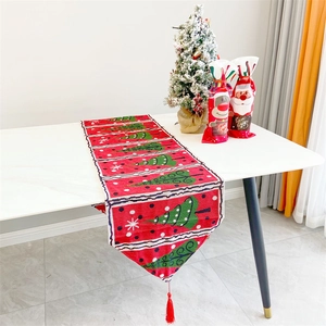 Red and green Christmas table runner with tassels and 'Warm Wishes' print on white table