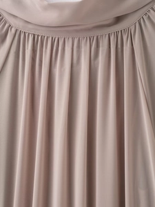 Detail of round neckline with pleated chiffon fabric on a light champagne dress