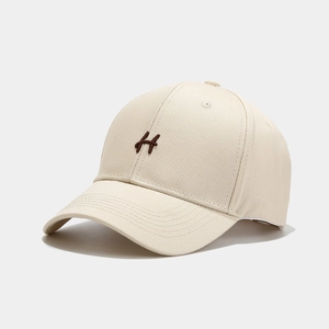 Berretto da baseball in cotone beige con lettera H ricamata e visiera curva parasole