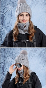Detail of grey knitted winter hat with pompom and matching neck warmer with buttons