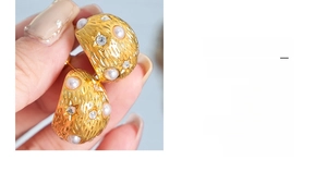 Dettaglio di orecchini vintage dorati con perle finte e strass scintillanti