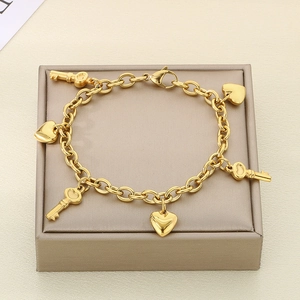 Gold stainless steel bracelet with heart and key charms on a premium jewelry box