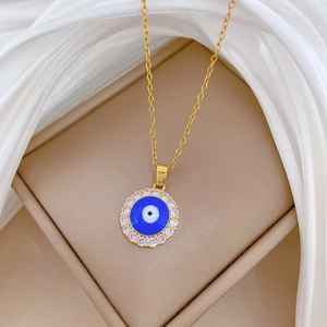Detailed close-up of gold Evil Eye necklace with blue center and sparkling zircons