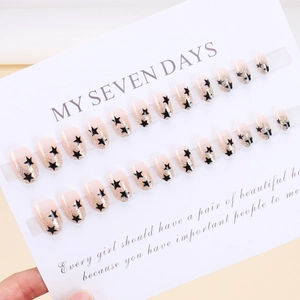 Short almond press-on nails set with nude base, black stars and silver glitter detail
