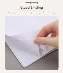 Detail of glue-bound lined notebook showing strong binding and smooth paper flexibility
