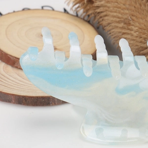 Macro shot of blue-white gradient acrylic hair claw clip with golden glitter details