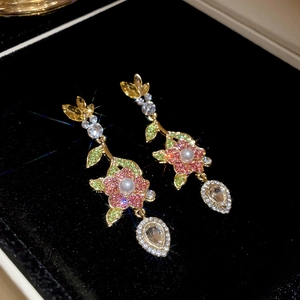 Macro di orecchini a fiore con cristalli rosa e pendenti a forma di goccia di pera