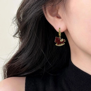 Vintage gold rocking horse earrings with red enamel and pavé crystals on a model