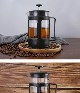 French Press coffee maker on wooden tray with coffee beans and detailed top view