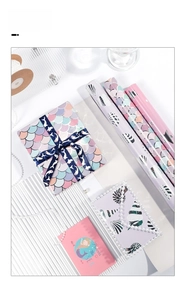 Vista dettagliata della carta regalo a sirena con motivi a scaglie e decorazioni a nastro
