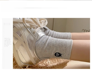 Detailed close-up of grey speckled ribbed mid-calf sock featuring a cute cat embroidery