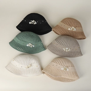 Detail of multi-color hollow-out knit bucket hats with pearl and floral decorations