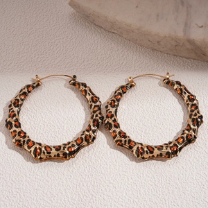 Vue détaillée des boucles d'oreilles léopard style bambou sur un support en pierre
