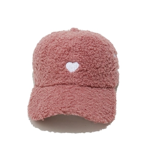 Detail of pink fleece baseball cap with white heart embroidery and warm fuzzy texture