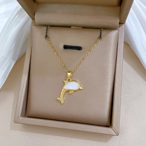Detailed macro view of the gold dolphin pendant with shell inlay and zircon accents