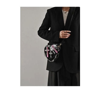 Detail of Y2K punk heart-shaped crossbody bag with silver chains and cross pendants