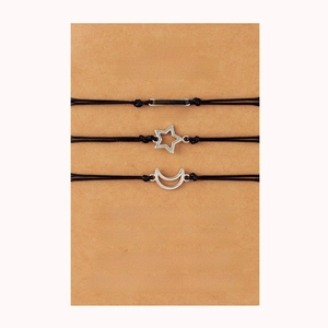 Close-up of three black woven friendship bracelets with sun moon and star silver charms