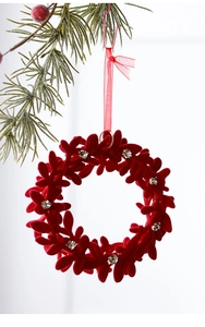 Detail of burgundy flocked Christmas wreath ornament with festive silver glitter accents