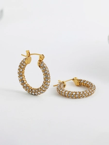 Detailed close-up of 18K gold-plated hoop earrings with micro-paved white zircons