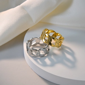 Macro detail of gold and silver chain link rings on a white minimalist display