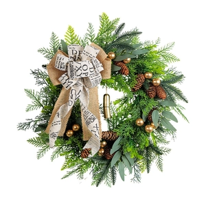 Rustic Christmas wreath featuring natural pinecones, gold bells, and newspaper bow