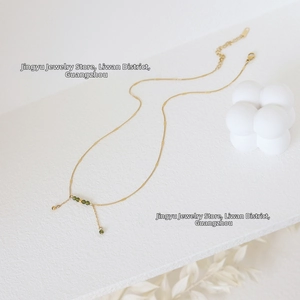 Detail of gold chain necklace with olive green beads and adjustable lobster clasp