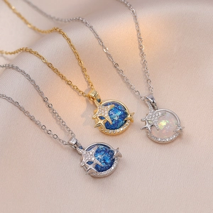 Detail of dream planet necklace featuring blue star zircon and white opal on silk fabric