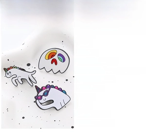 Detail showing cartoon enamel pins set with white rainbow ghost and dinosaur motifs
