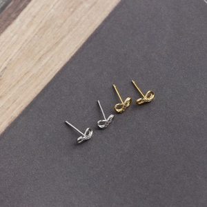 Detail of silver and gold infinity stud earrings with sparkling cubic zirconia stones