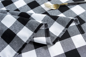 Close-up detail of black and white checkered cotton fabric texture with a metal fork