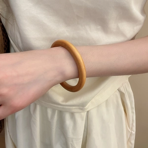Gros plan d'un bracelet en bois brun chaud avec grain naturel et finition polie