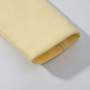 Close-up of light yellow wool blend fabric texture and stitching detail on the sleeve