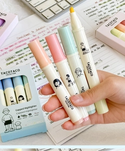 Close-up of pastel highlighters set on a notebook and keyboard for study use