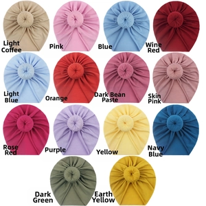 Detailed palette of baby donut beanies in fourteen soft colors with ribbed knit texture