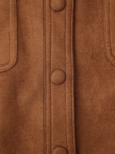 Detalle macro de la textura de ante marrón y botones forrados en la chaqueta