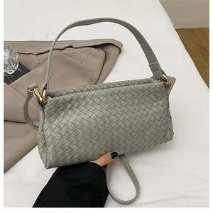 Détail de la texture tissée d'un sac bandoulière vert sauge avec crochets dorés