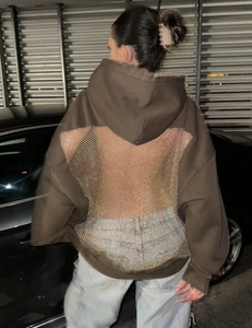 Detail eines dunkelbraunen Hoodies mit Rückenausschnitt und silbernem Strassnetz