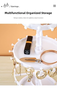 Detailed view of white rotating multi-layer jewelry stand with functional hooks and trays