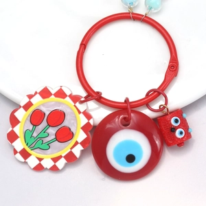 Macro shot of colorful keychain with tulip charm, blue evil eye, and red doll figure