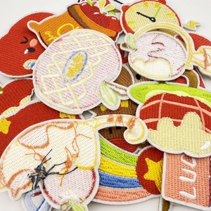 Macro view of assorted cartoon fruit and star embroidered patches with 3D texture