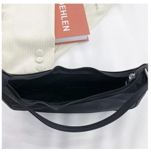 Detailed top view of black nylon shoulder bag with silver zipper and large inner compartment