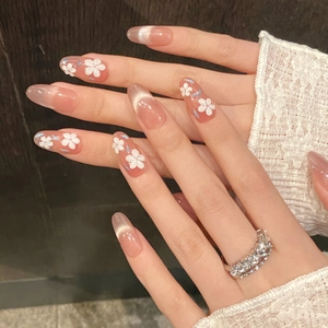 Nude pink cat eye press-on nails with 3D white floral accents in almond shape