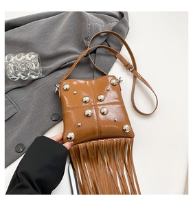 Detailed close-up of vintage brown tassel bag with metallic rivet accents and chain strap