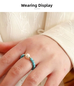 Detail of beaded ring featuring a freshwater pearl and blue turquoise beads on hand