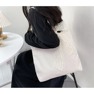 Polka dot canvas tote bag with large lace bow detail shown on shoulder for daily use