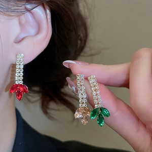 Detail of luxury zircon tassel earrings with marquise-cut gems in red, green and champagne