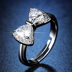 Detailed close-up of bow-knot ring with triangle zircons and adjustable silver band